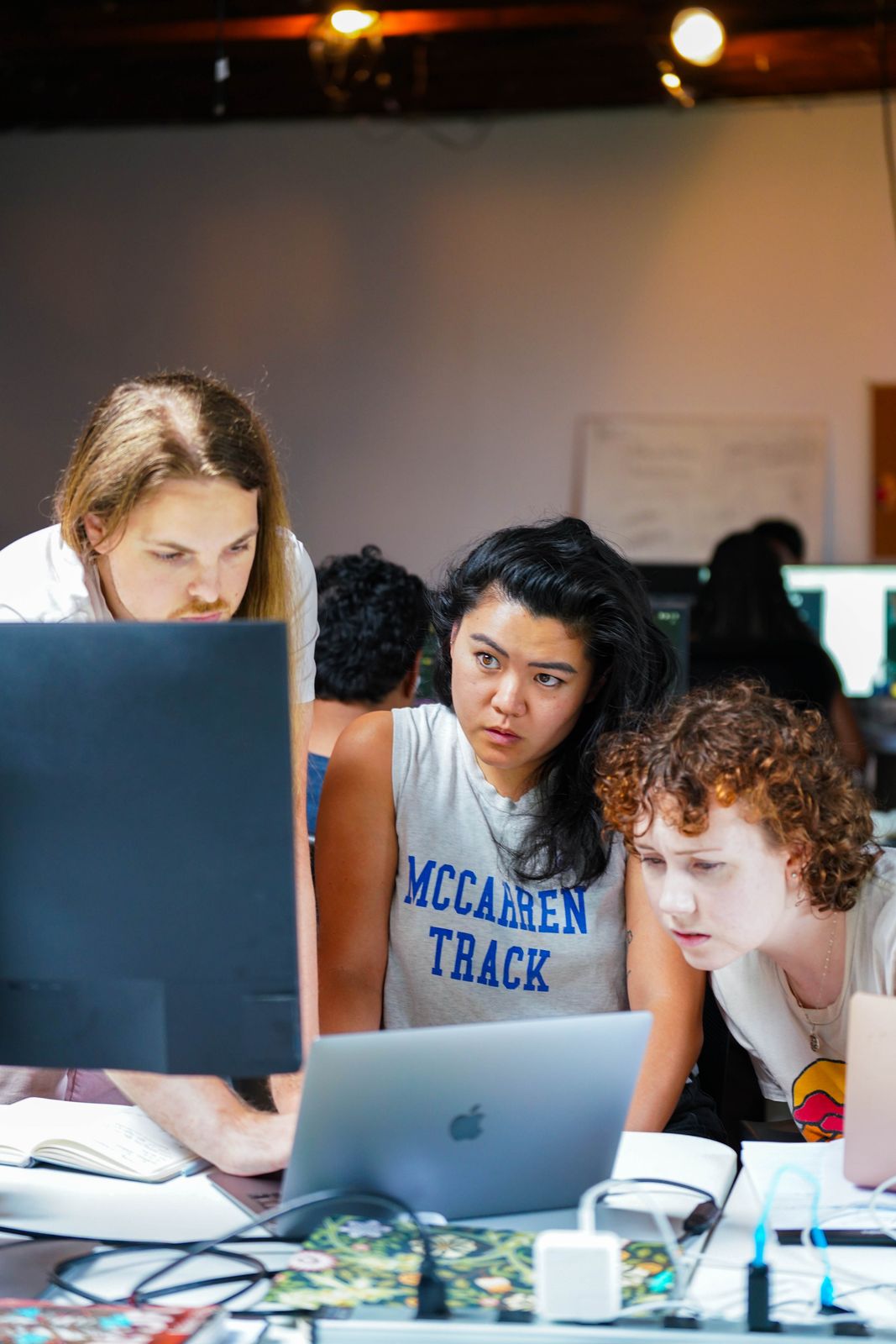 Students collaborating around laptops at Fractal Campus